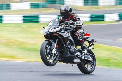 The Tuono 660 Factory wheelies over the mountain at Cadwell Park